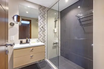 a bathroom with a sink and a glass shower at Golf Promenade 2-B, Damac Hills - 2BR Apartment - Allsopp & Allsopp in Dubai