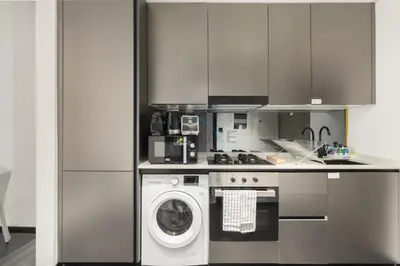a kitchen with a washing machine and a washer at Studio Just Minutes Drive to Downtown Dubai Top Attractions, Close to Zabeel Stadium, O10 Building, Al Jaddaf by Deluxe Holiday Homes in Dubai
