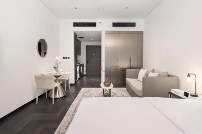 a white living room with a couch and a table at Studio Just Minutes Drive to Downtown Dubai Top Attractions, Close to Zabeel Stadium, O10 Building, Al Jaddaf by Deluxe Holiday Homes in Dubai