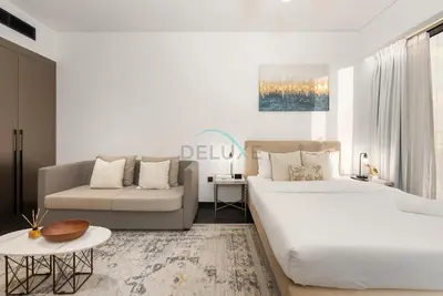 a bedroom with a large bed and a couch at Studio Just Minutes Drive to Downtown Dubai Top Attractions, Close to Zabeel Stadium, O10 Building, Al Jaddaf by Deluxe Holiday Homes in Dubai