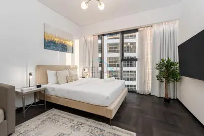 a bedroom with a large white bed and a desk at Studio Just Minutes Drive to Downtown Dubai Top Attractions, Close to Zabeel Stadium, O10 Building, Al Jaddaf by Deluxe Holiday Homes in Dubai