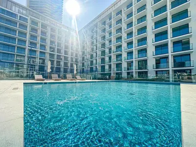 a large swimming pool in front of a building at WelHome - Perfect Cozy Studio with Pool, Gym & Balcony in Dubai