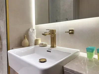a white sink with a gold faucet in a bathroom at WelHome - Perfect Cozy Studio with Pool, Gym & Balcony in Dubai