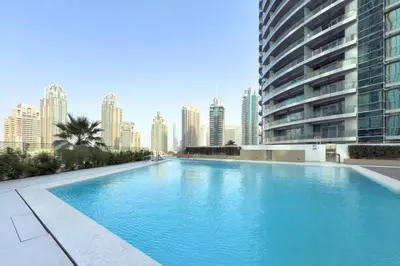 a large swimming pool with a city skyline in the background at Modern 1 Bed Apartment with full Dubai Marina view in Dubai
