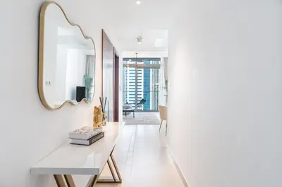 a hallway with a white table and a mirror at Dubai Marina Luxury 1 BDR Holiday Apartment - Dubai Marina Walk in Dubai