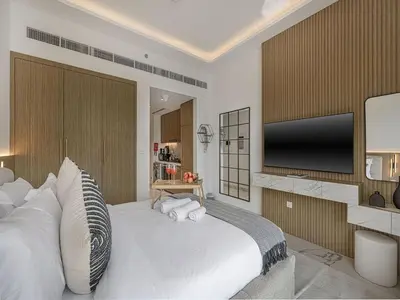 a bedroom with a large bed with a flat screen tv at Livin' Holidays - Studio - Azizi Elegant Studio in Dubai
