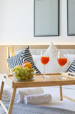 two wine glasses and a bowl of fruit on a coffee table at Livin' Holidays - Studio - Azizi Elegant Studio in Dubai