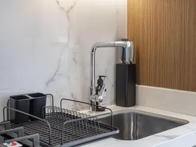 a kitchen sink with a dish drying rack next to it at Livin' Holidays - Studio - Azizi Elegant Studio in Dubai