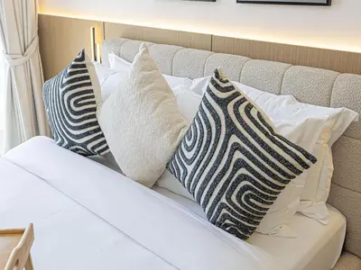 a bed with pillows on top of it at Livin' Holidays - Studio - Azizi Elegant Studio in Dubai