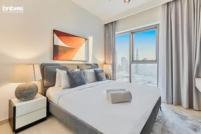 a bedroom with a large bed and a large window at bnbmehomes - Downtown Views II - Tower 1 in Dubai