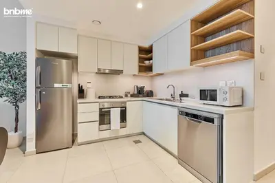 a kitchen with white cabinets and stainless steel appliances at bnbmehomes - Downtown Views II - Tower 1 in Dubai