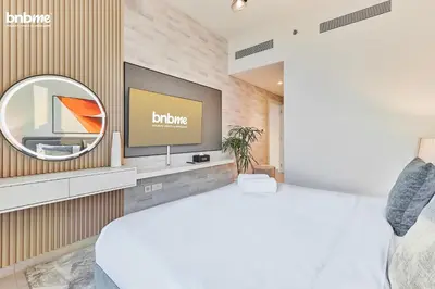 a bedroom with a bed and a tv on a wall at bnbmehomes - Downtown Views II - Tower 1 in Dubai