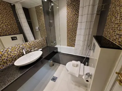 a bathroom with a sink and a shower and a toilet at Downtown Dubai Burj Khalifa View 2 BHK Dubai Mall in Dubai