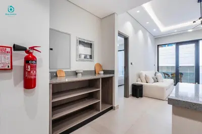 a living room with a fire extinguisher on the wall at Blue Breeze - Stylish 1 BR in JVC Al Serh Residence in Dubai