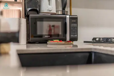 a microwave oven sitting on a kitchen counter at Blue Breeze - Stylish 1 BR in JVC Al Serh Residence in Dubai