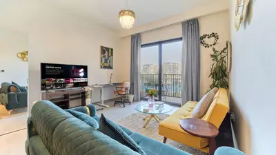 a living room with a couch and a tv at 1BR Dubai Hills Executive Residence Stylish Stay in Dubai