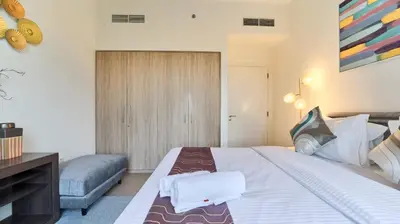 a bedroom with a large bed with towels on it at 1BR Dubai Hills Executive Residence Stylish Stay in Dubai