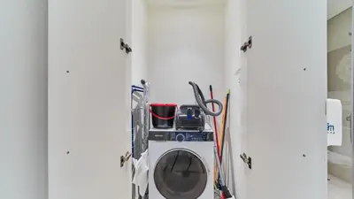 a washer and dryer in a room with skis at 1BR Dubai Hills Executive Residence Stylish Stay in Dubai