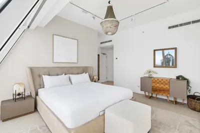 a white bedroom with a bed and a chair at Ultra-Luxury Penthouse Private Pool & Yacht Views in Dubai