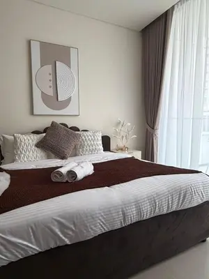 a bedroom with a large bed with towels on it at Stylish Studio JVC I Epic Amenities I Near Mall in Dubai