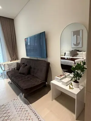 a living room with a couch and a mirror at Stylish Studio JVC I Epic Amenities I Near Mall in Dubai