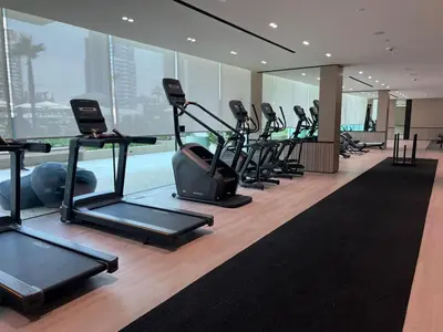 a gym with a row of treadms and elliptical machines at Stylish Studio JVC I Epic Amenities I Near Mall in Dubai