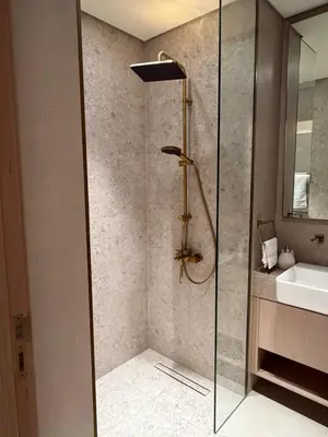 a shower with a glass door next to a sink at Stylish Studio JVC I Epic Amenities I Near Mall in Dubai