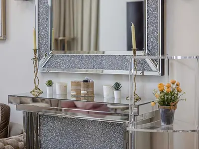 a mirror and a shelf with plants and candles at Livin' Holidays - 1 BR - Elegant Apartment in Dubai