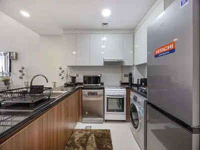 a kitchen with a washer and dryer in it at Livin' Holidays - 1 BR - Elegant Apartment in Dubai