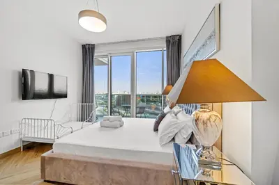 a bedroom with a bed and a large window at Contemporary 1BR City View Apartment at 1 Residence in Dubai