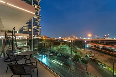 a balcony with a table and chairs on top of a building at Contemporary 1BR City View Apartment at 1 Residence in Dubai
