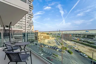 a balcony with a table and chairs and a view of a city at Contemporary 1BR City View Apartment at 1 Residence in Dubai