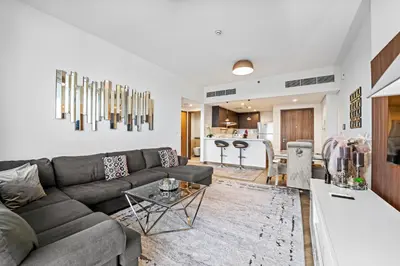 a living room with a couch and a kitchen at Contemporary 1BR City View Apartment at 1 Residence in Dubai