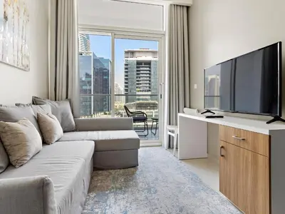 a living room with a couch and a flat screen tv at Executive 1BDR Sleeps 4 In Vera-Business Bay-80 in Dubai