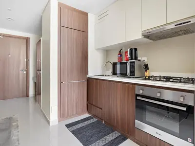 a kitchen with wooden cabinets and a stove top oven at Executive 1BDR Sleeps 4 In Vera-Business Bay-80 in Dubai