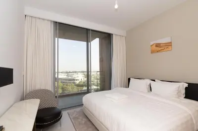 a bedroom with a white bed and a large window at 1 BDR Ellington House, Dubai Hills in Dubai