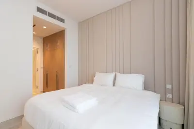 a white bed with white sheets and pillows at 1 BDR Ellington House, Dubai Hills in Dubai