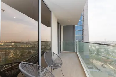 a balcony with two chairs and a view of a city at Boutique 2BDR Ellington House, Dubai Hills in Dubai