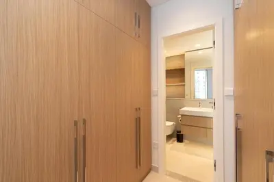 a bathroom with wooden cabinets and a toilet and a sink at Boutique 2BDR Ellington House, Dubai Hills in Dubai