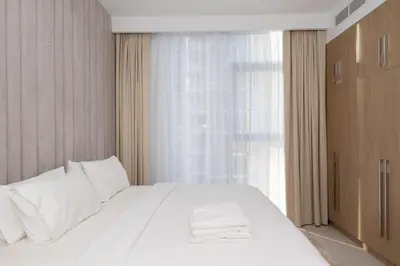 a bedroom with a large white bed and a window at Boutique 2BDR Ellington House, Dubai Hills in Dubai