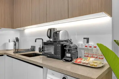 a kitchen with a coffee maker on a counter at Waves - Modern Comfort in JVC - Elegant 1BR Stay in Dubai