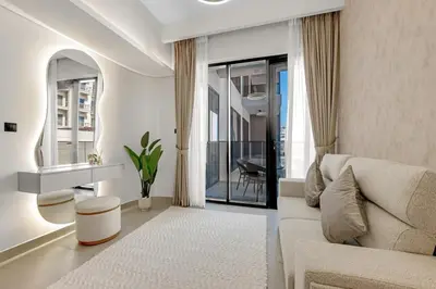 a living room with a couch and a table at Waves - Modern Comfort in JVC - Elegant 1BR Stay in Dubai