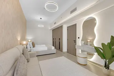 a white bedroom with a bed and a couch at Waves - Modern Comfort in JVC - Elegant 1BR Stay in Dubai