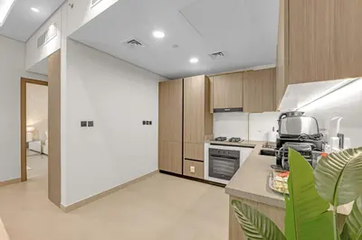 a kitchen with wooden cabinets and a counter top at Waves - Modern Comfort in JVC - Elegant 1BR Stay in Dubai