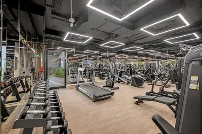 a gym with rows of treadmills and machines at Waves - Modern Comfort in JVC - Elegant 1BR Stay in Dubai