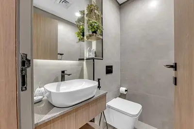 a bathroom with a white sink and a toilet at Waves - Modern Comfort in JVC - Elegant 1BR Stay in Dubai