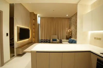 a kitchen and living room with a television and a couch at OLD The Royal Blue Jacuzzi Suite 3501 in Dubai