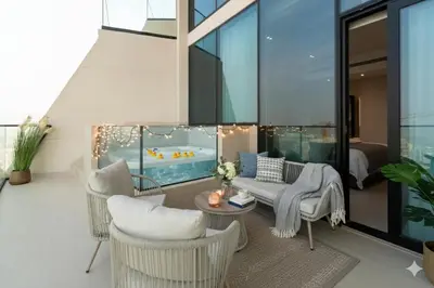 a living room with chairs and a couch and a table at OLD The Royal Blue Jacuzzi Suite 3501 in Dubai