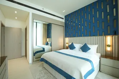 a bedroom with two beds and a blue wall at OLD The Royal Blue Jacuzzi Suite 3501 in Dubai