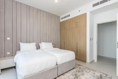 a bedroom with a large bed with white sheets at Luxury 3BDR Ellington House Dubai Hills in Dubai